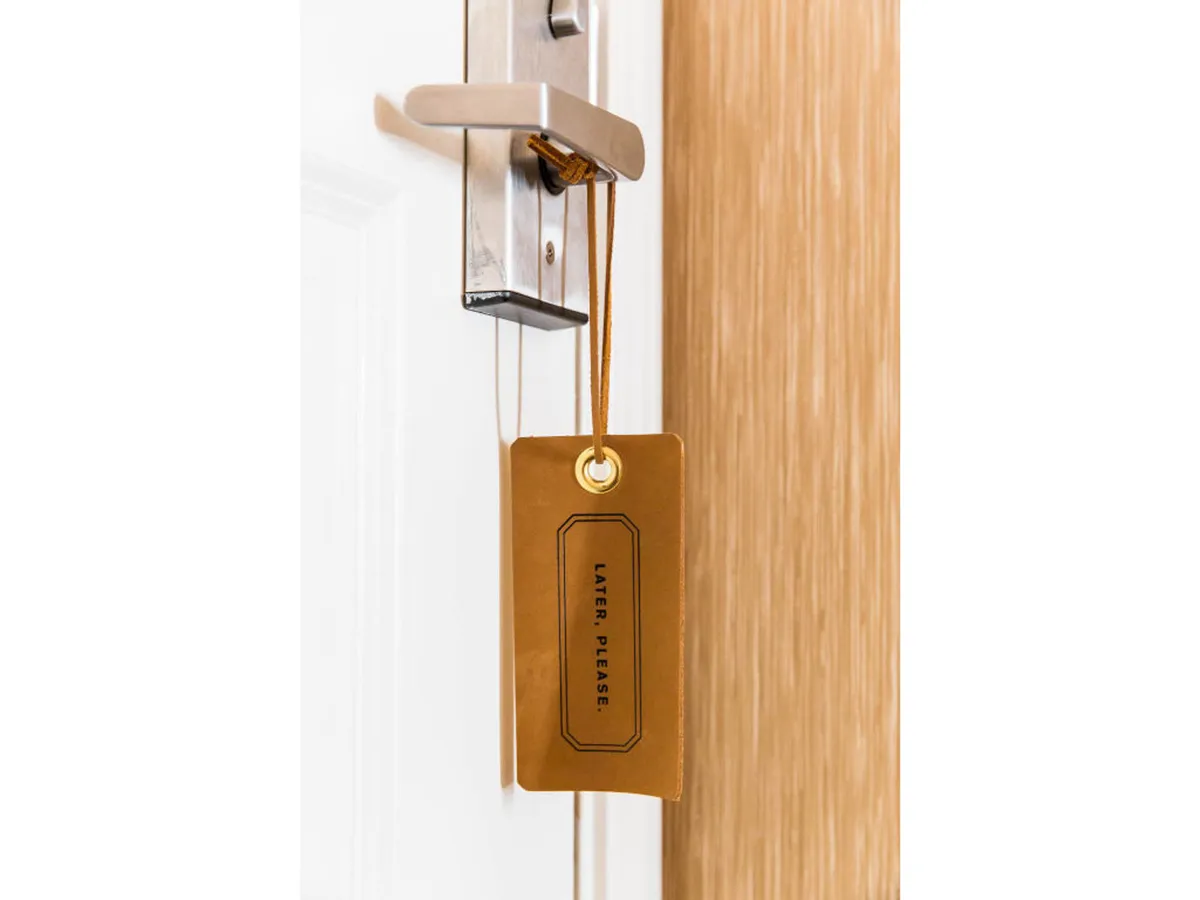 A close-up of a tranquil moment—showing a door handle with a door tag, suggesting privacy and a peaceful retreat. The mood is serene, resonating with relaxation and intimate escapes.